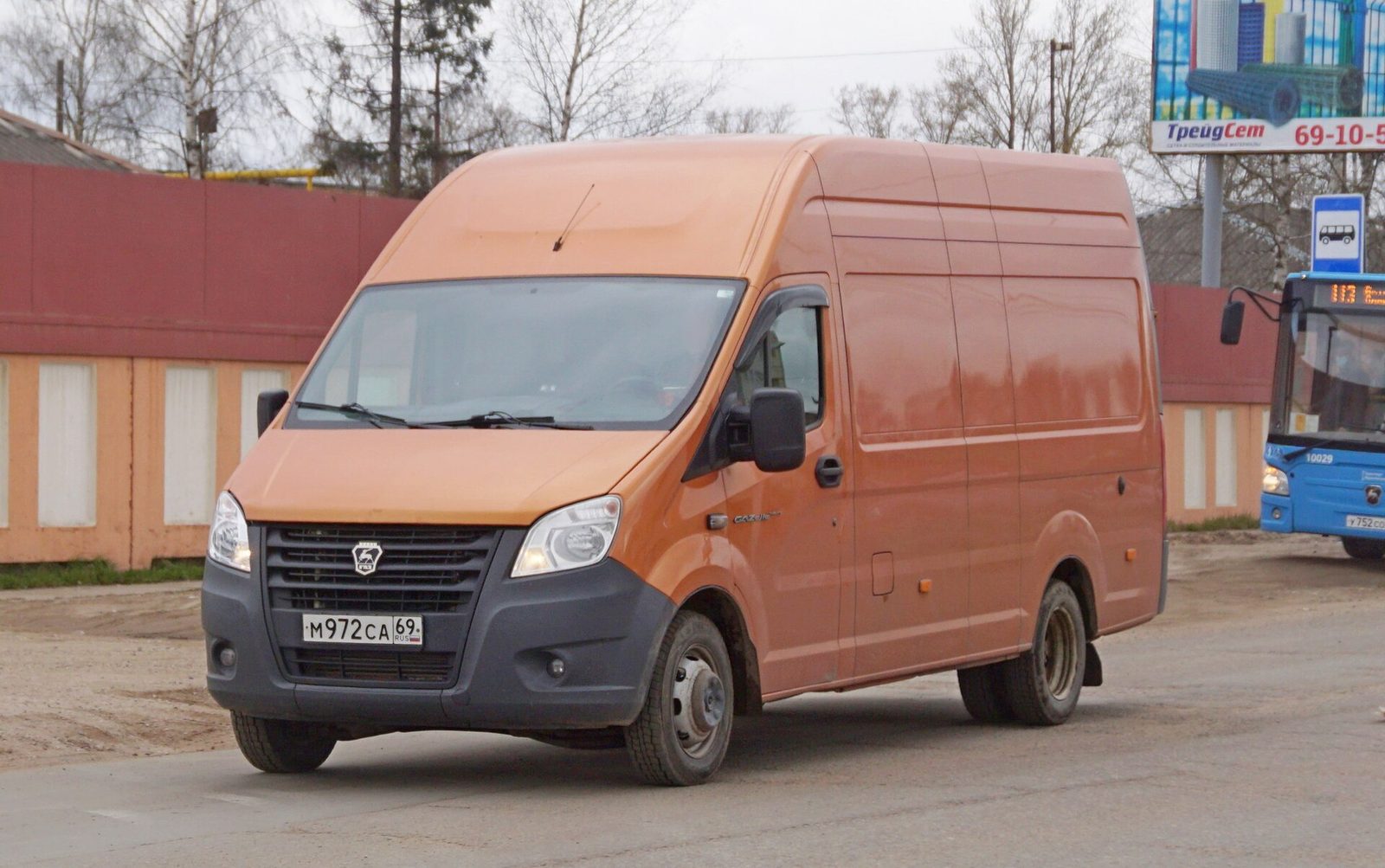 Оранжевый фургон ГАЗель Next на городской улице