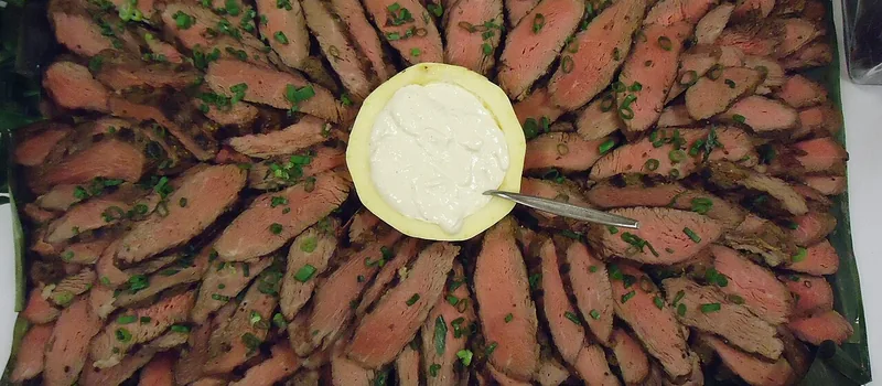 Нарезанный стейк на блюде с соусом